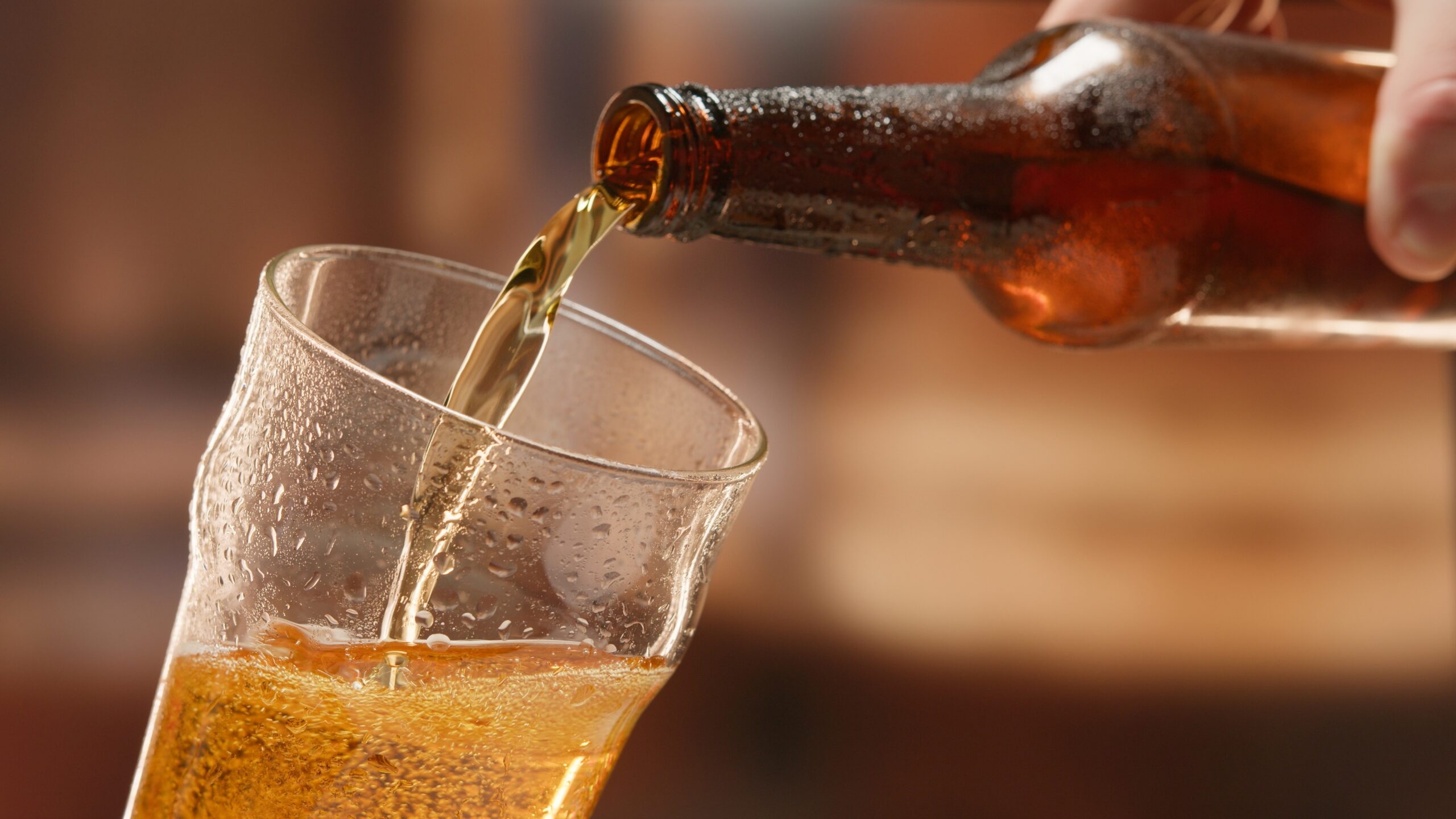 Beer,Is,Poured,From,Dark,Brown,Bottle,Into,Beer,Glass.